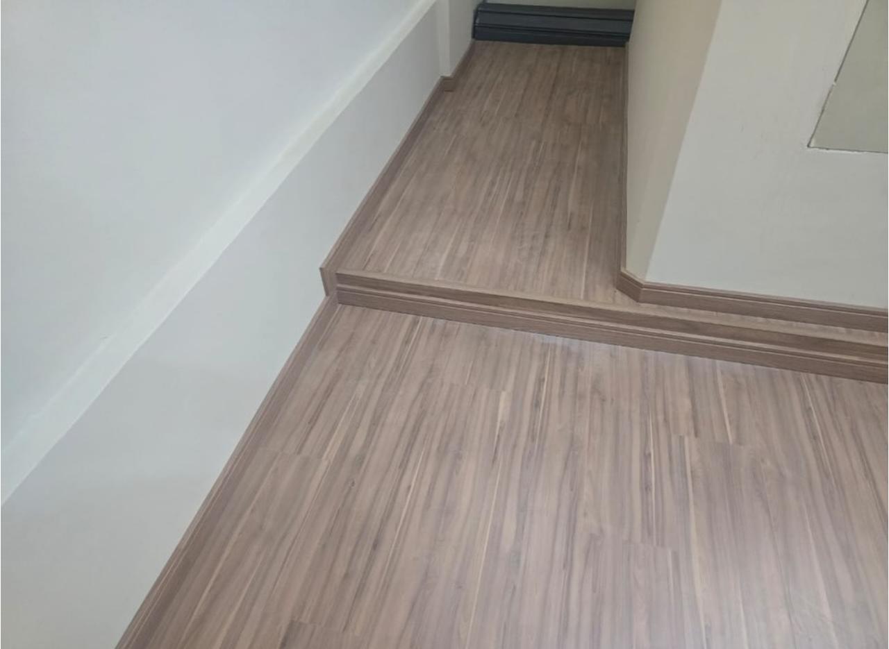 Detalhe de piso laminado com rodapé no mesmo tom da régua